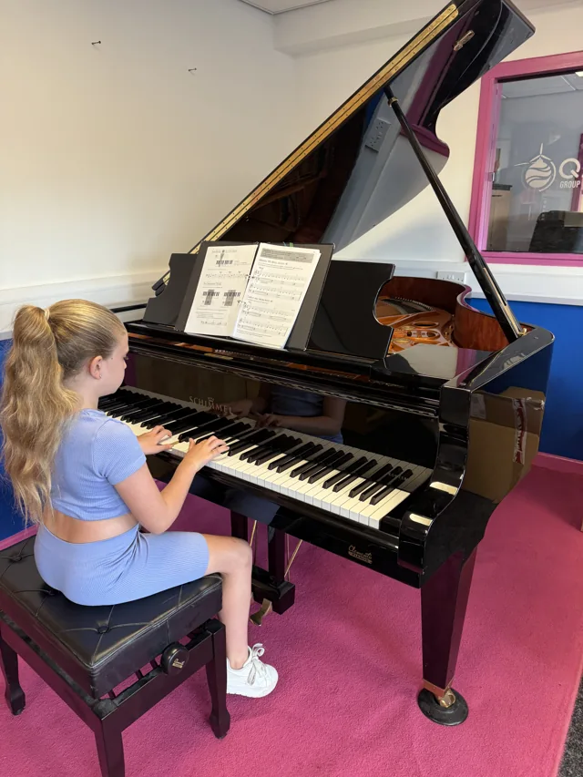 A pupil practising on the grand piano at The Piano Lab